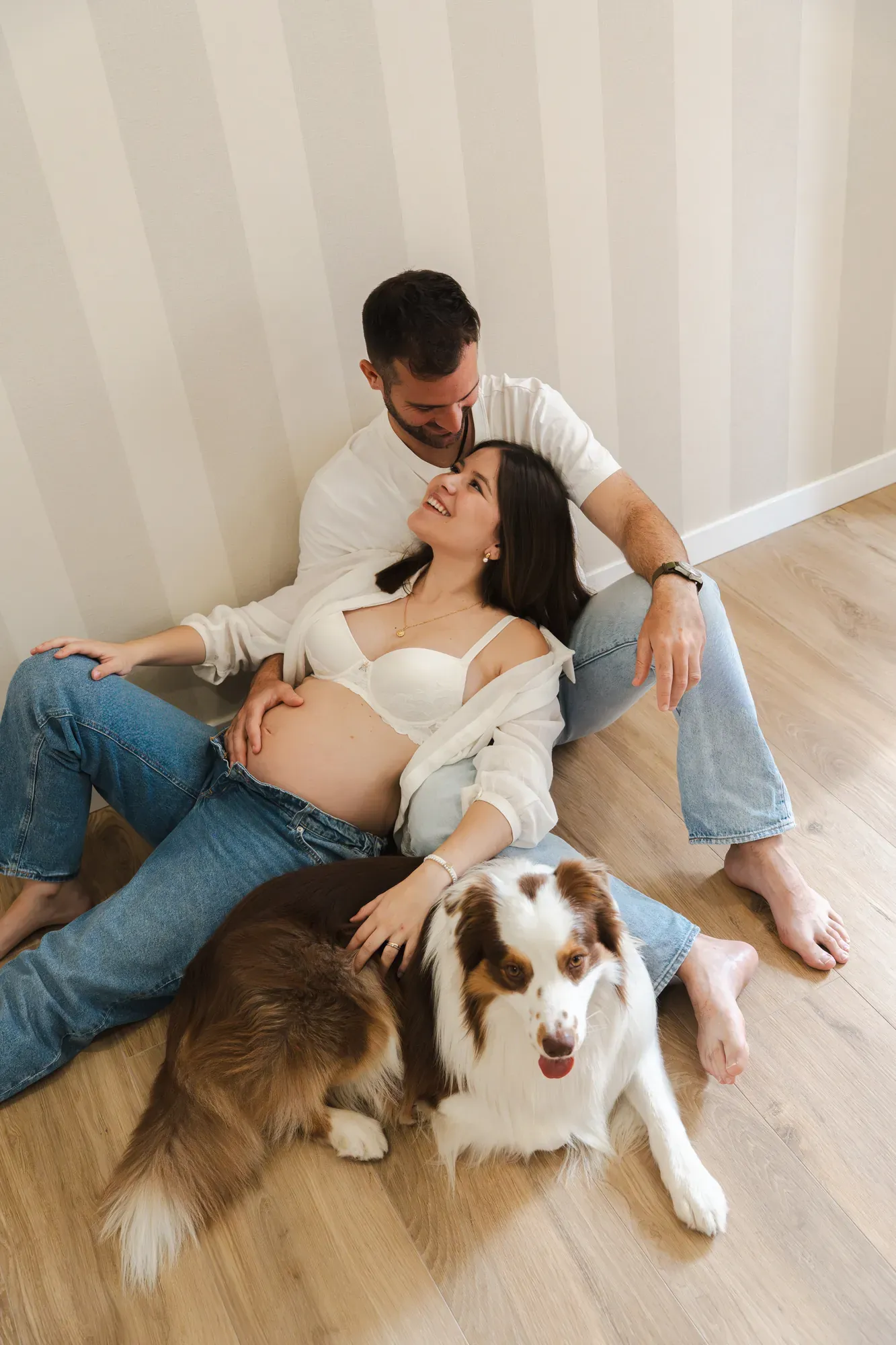 Pareja sentada en el suelo junto a su perro